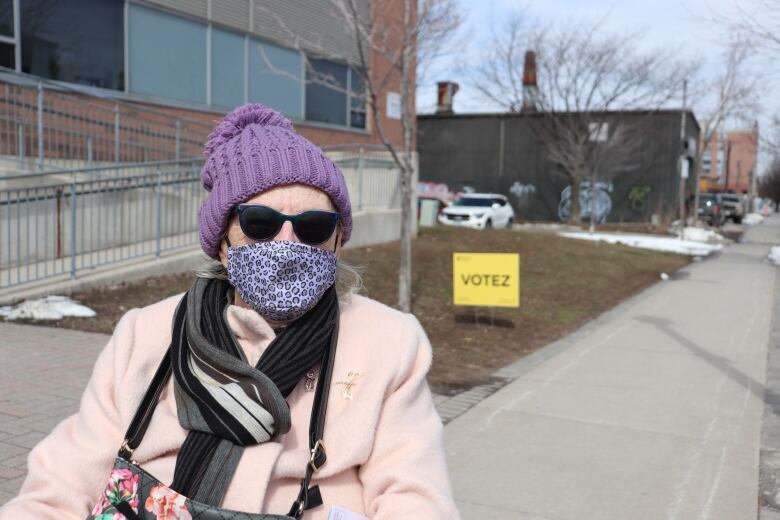 An older woman in front of an Elections Ontario sign. 