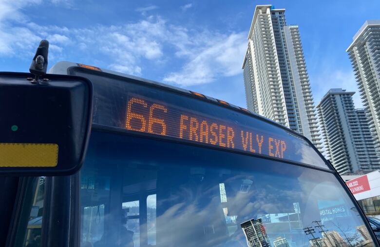 The sign of the 66 Fraser Valley Express bus is lit up at a bus stop.