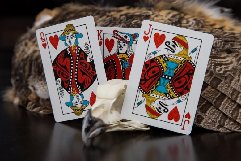 A queen, king and jack playing cards with Indigenous designs instead of traditional cards