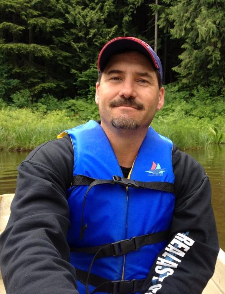 adult photo of Damon Grant in a life jacket in a boat