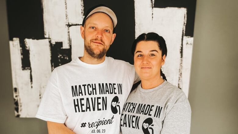 A man, left, and a woman, right, both wearing t-shirts that say 