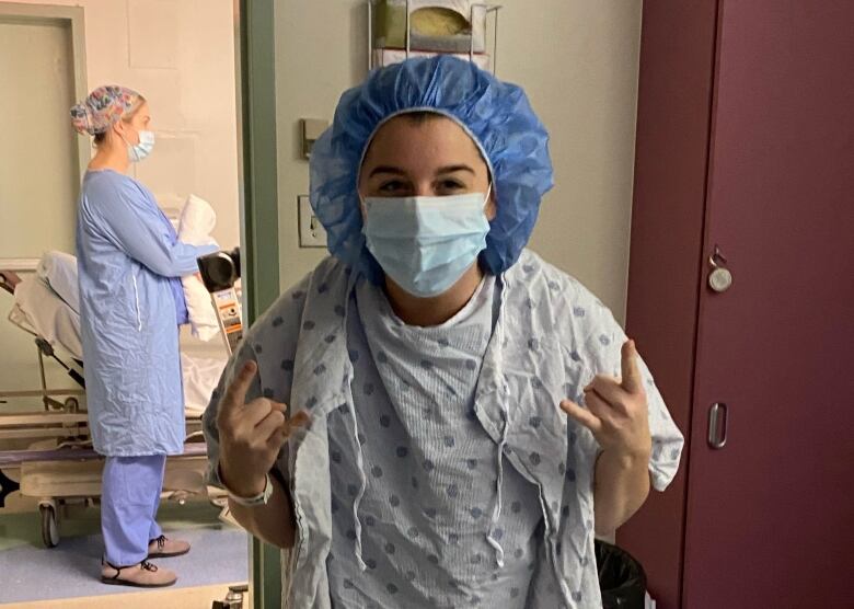 A woman wearing a blue hospital gown and hair cap