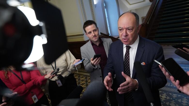 Man surrounded by reporters and cameras