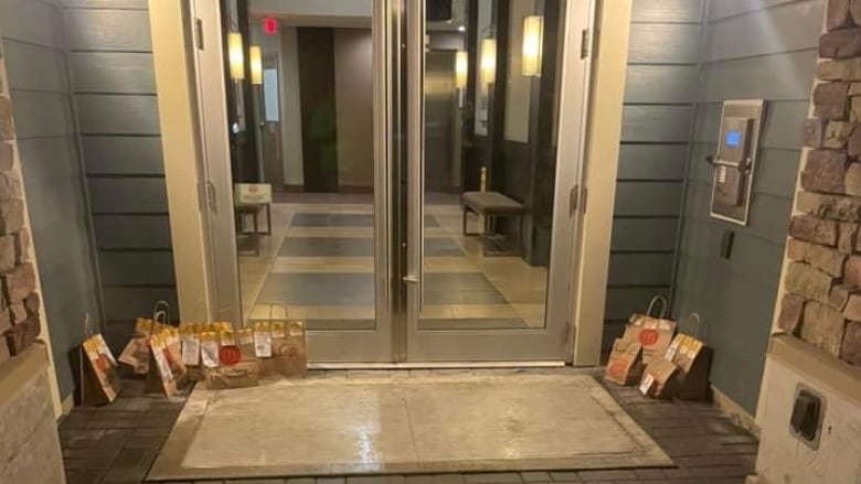 McDonald's delivery bags in front of a condo building door.