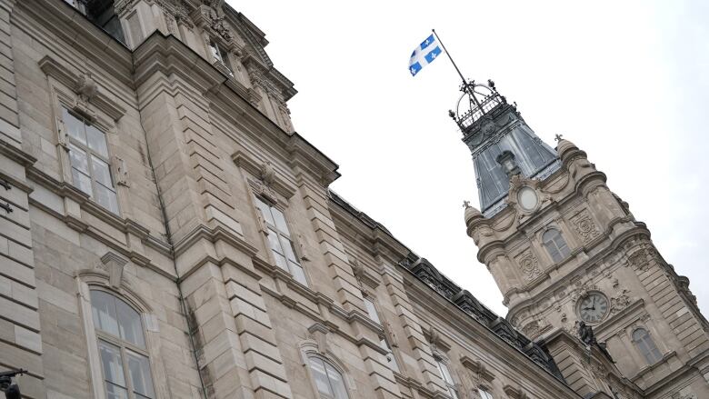 Exterior of greystone government building with Quebec fleur-de-lys flag.