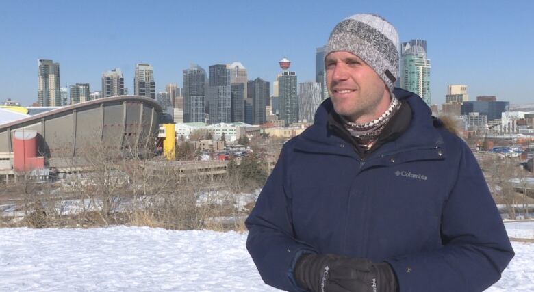 A man talking at a camera wearing a toque.