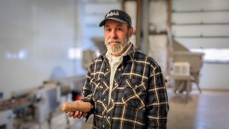 A man holds a bait sausage