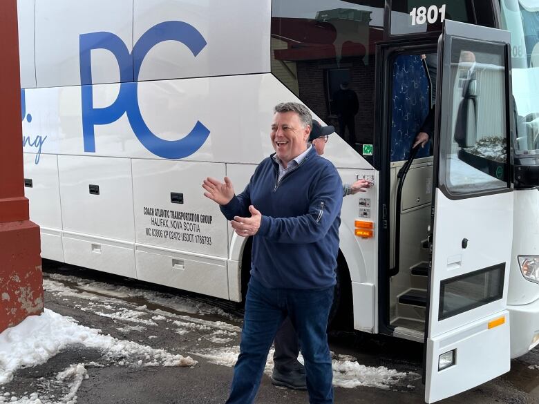 PEI Prime Minister Dennis King posing with the campaign bus for the Progressive Conservative Party.