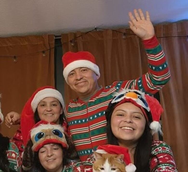 Family in matching Christmas pajamas on bed