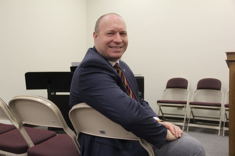 Josh Gruninger is seated in a chair. He looks back toward the camera.