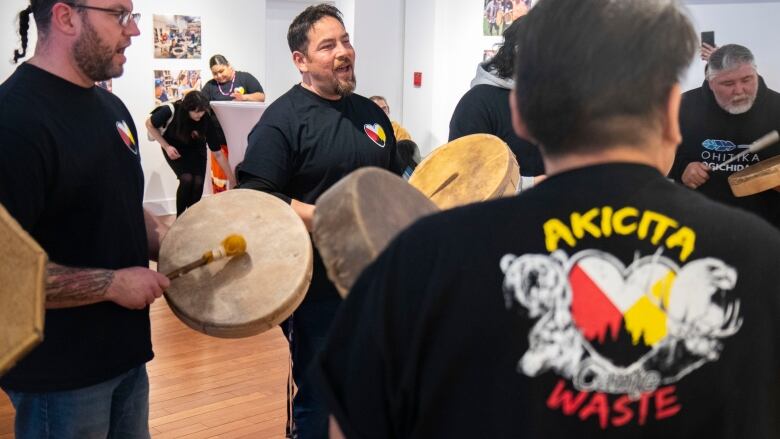 An Indigenous mens drum group sings.