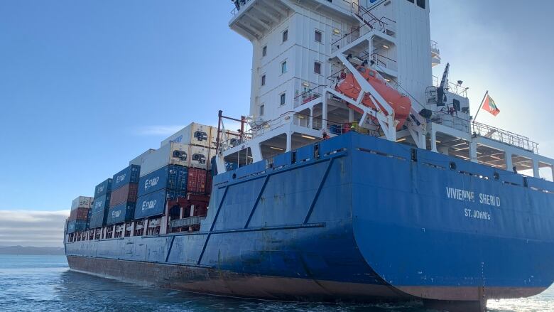 A cargo ship is pictured from the stern.