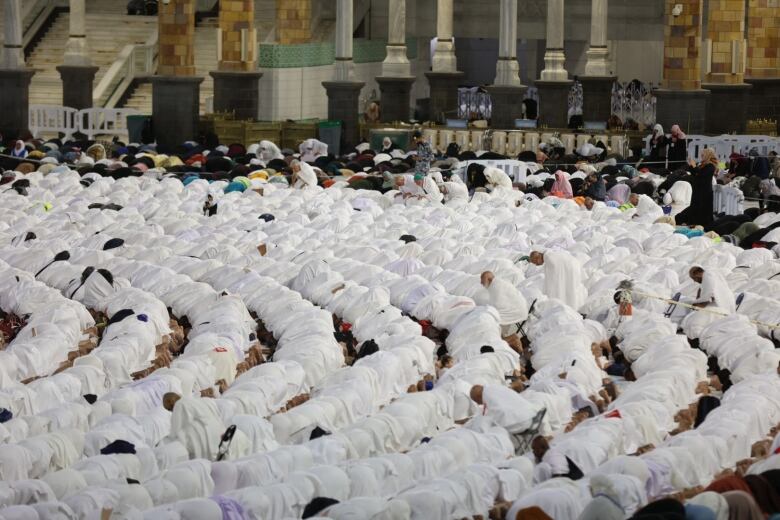 Worshippers in white garb pray at a mosque in the holy city of Mecca, Saudi Arabia.