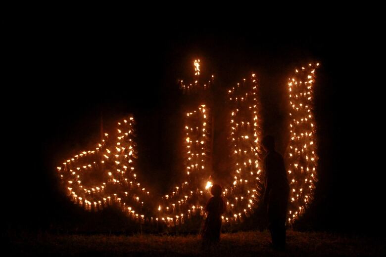 Lit torches at night that outline the word God to welcome the holy month of Ramadan.