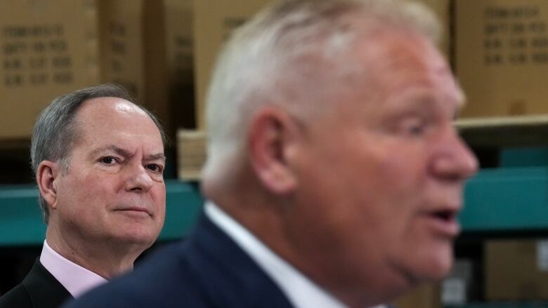 Finance Minister Peter Bethlenfalvy, left, listens to Premier Doug Ford speak after touring Oakville Stamping and Bending Limited on March 22, 2023.