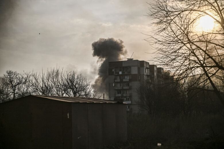 Smoke rises from an apartment building after it was shelled.