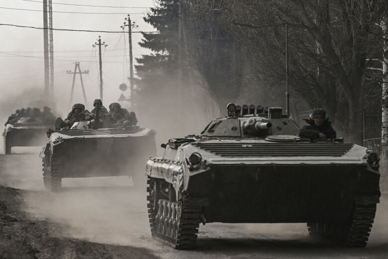 Ukrainian soldiers driving on a road.