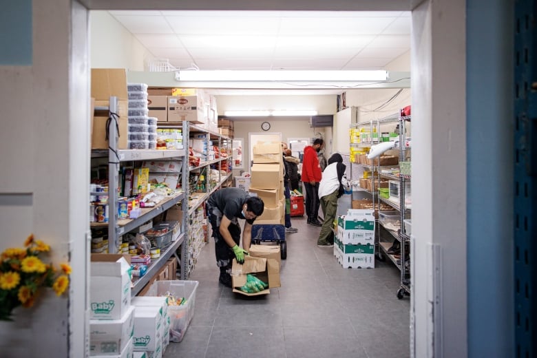 People stock shelves at a food bank for Muslim clientele in Scarborough, Ont.