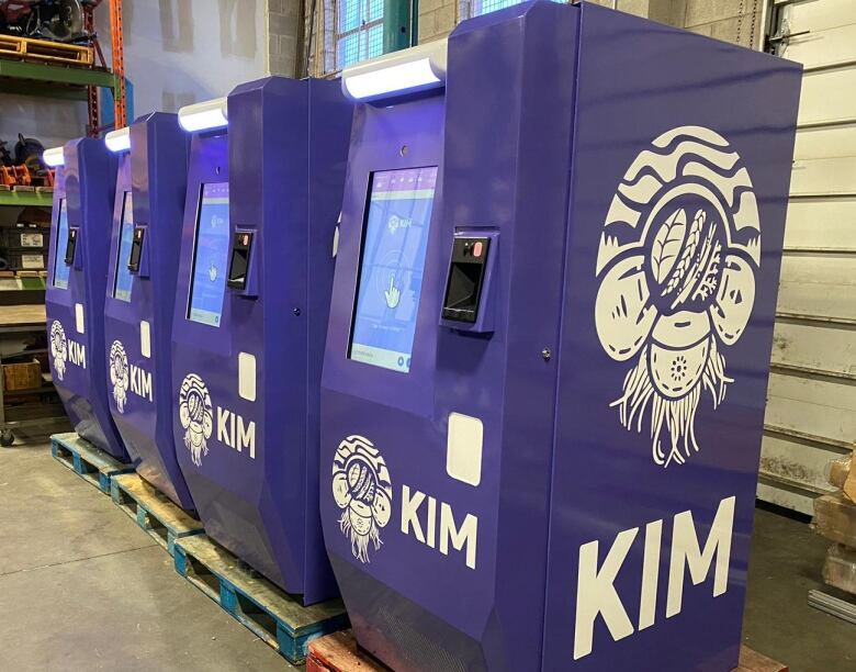 Four dispensing machines lined up with KIM's Logo. 