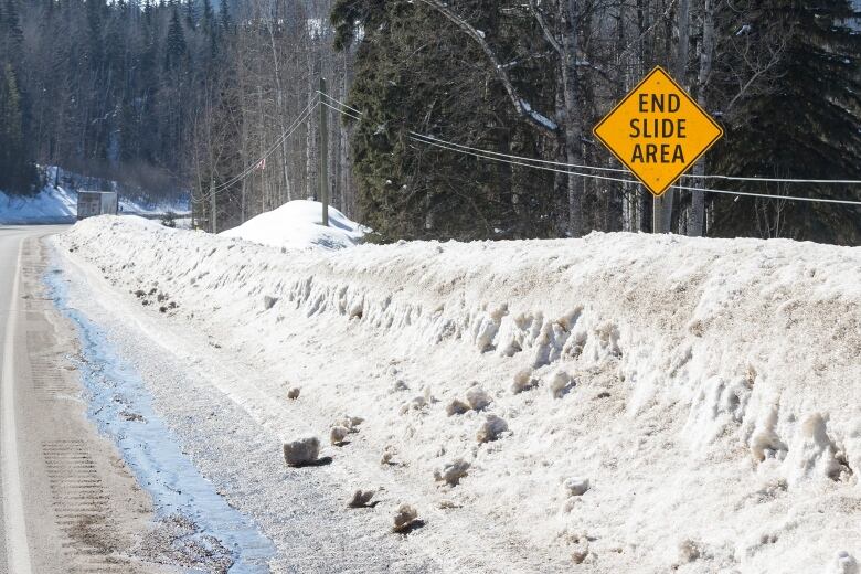 A yellow diamond-shaped highway sign that says 