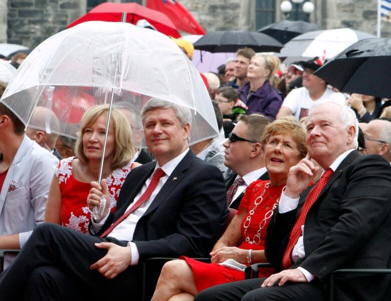 Prime Minister Stephen Harper and his wife Laureen (left) watch the Canada Day show along with Governor General David Johnston and his wife Sharon (right) on Parliament Hill in Ottawa on Wednesday, July 1, 2015.