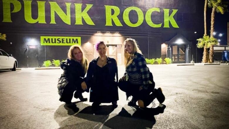 Three women in front of a museum.