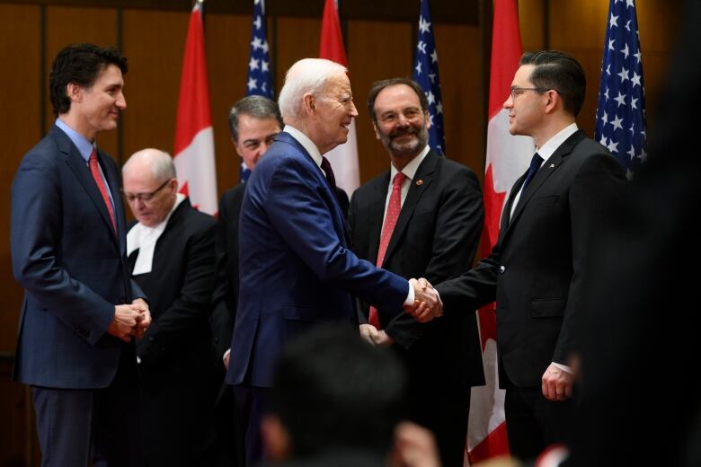 U.S. President Joe Biden shakes hands with Conservative Party of Canada Leader Pierre Poilievre, as Prime Minister Justin Trudeau looks on.