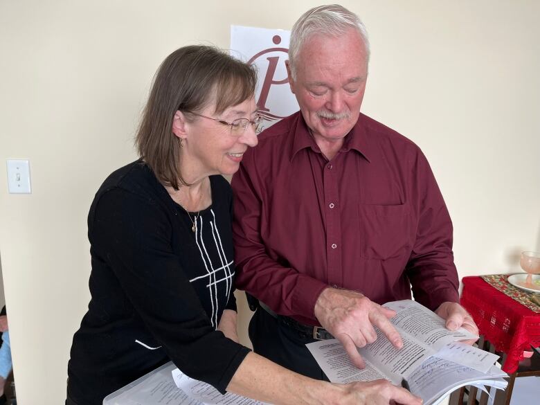 A woman and a man read a pamphlet 