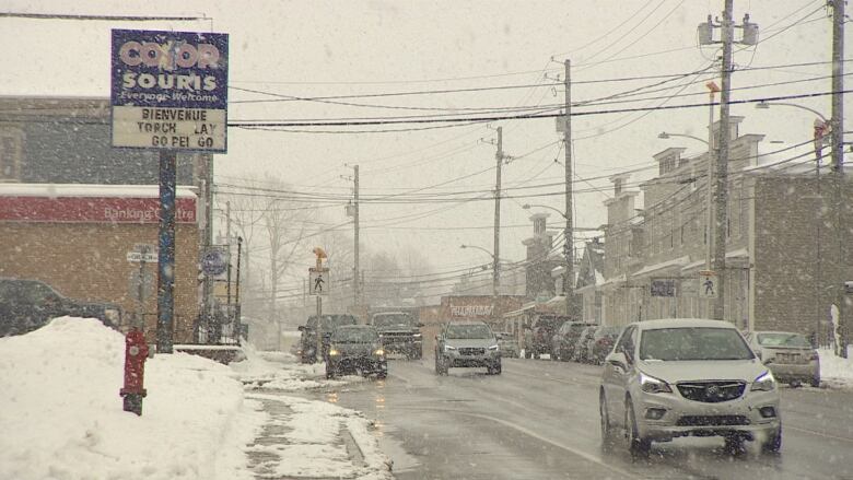 Snow falls on a street filled with cars in Souris, P.E.I. 