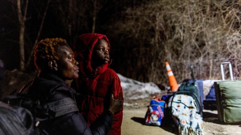 A woman and her child look longingly towards something. 