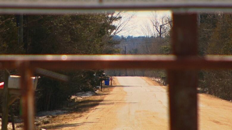 A fence blocks off a rural road. 