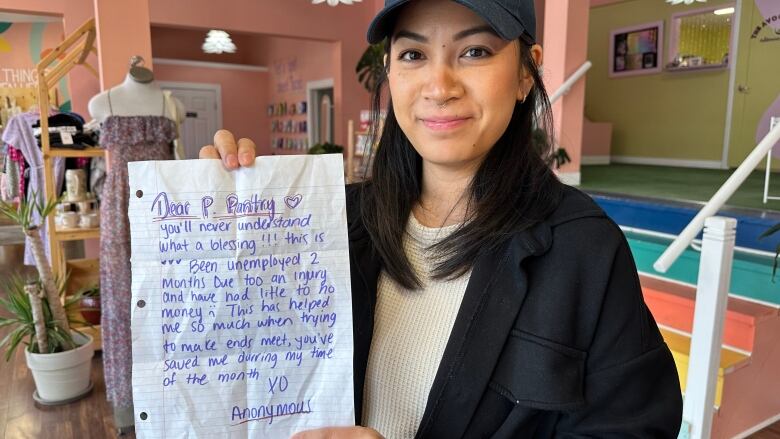 A woman holds a letter.