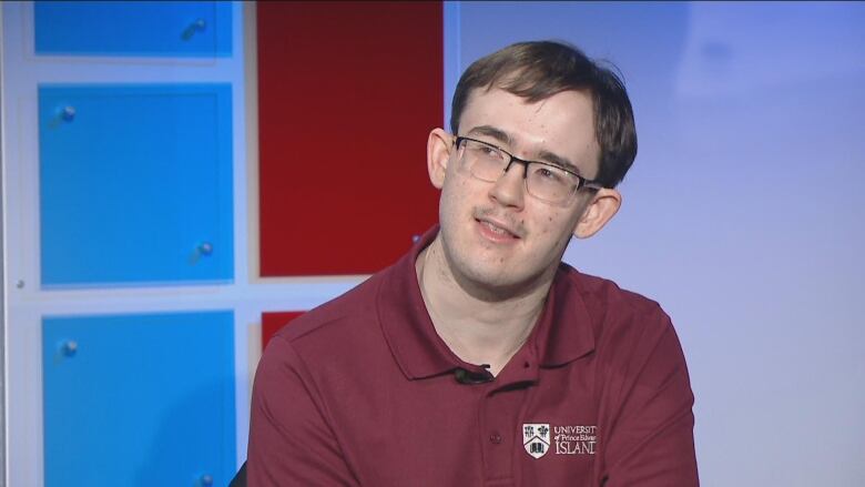 A university student sits in the TV studio