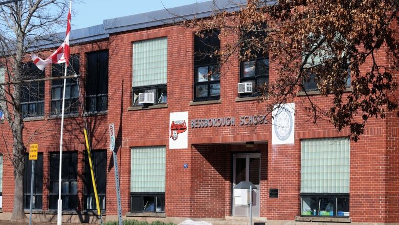 A two-storey red brick building with a sign over the doors saying 