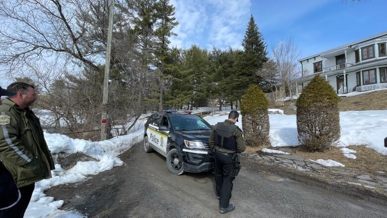 Provincial police stand outside a suburban house targeted by the search warrants. 