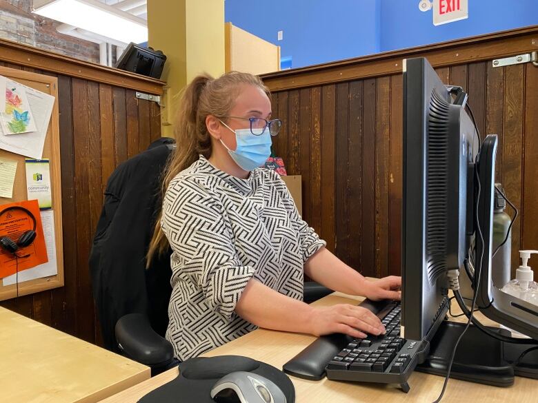 A woman sitting and working at a desk. 