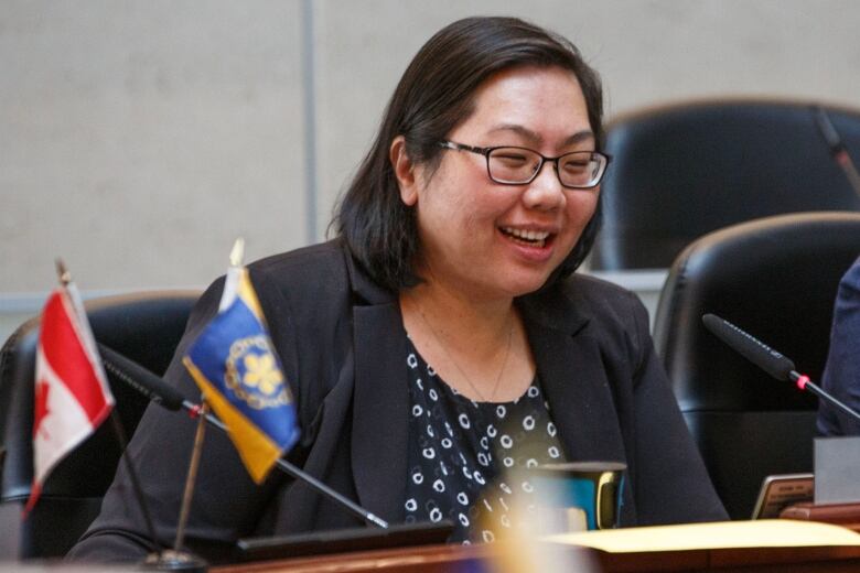 Woman sits at table smiling