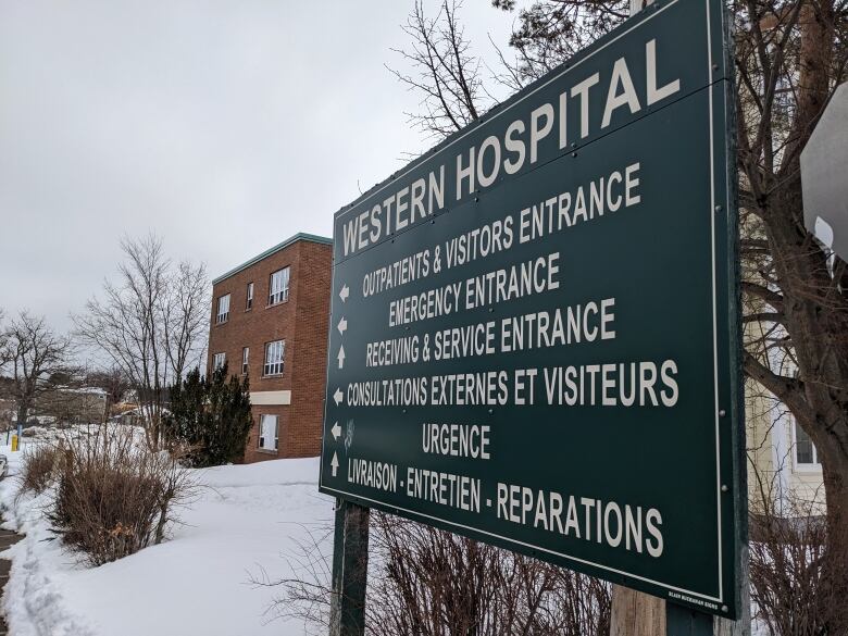 A hospital sign directs patients on which entrance to use outside a rural hospital. 