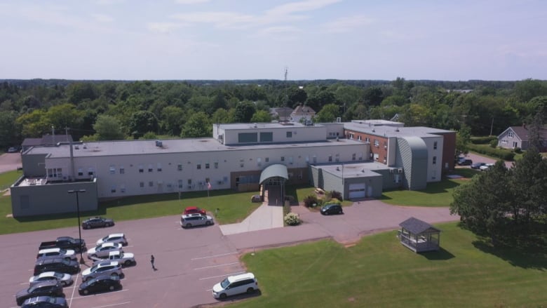 A drone shot of a rural hospital, with cars in the parking lot 