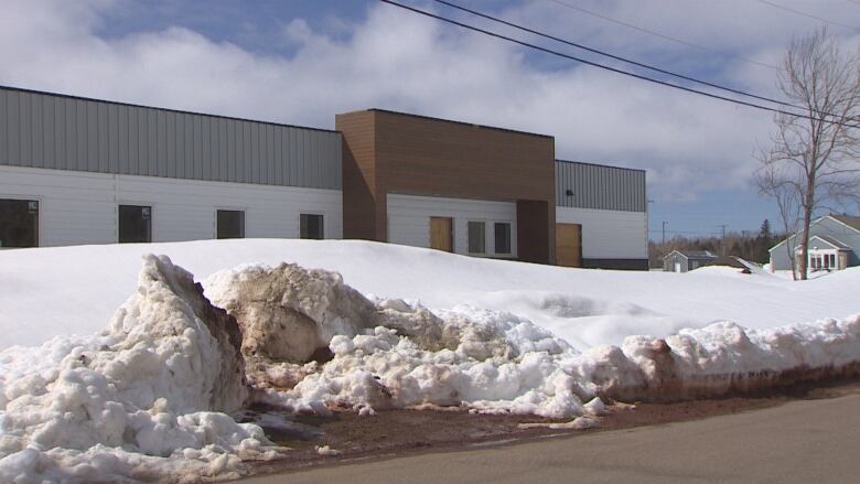 Snow banks hide a new building under construction, it will be a new medical clinic 