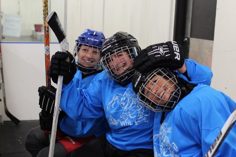 Players Laura Ouellette, Jordie Thomson and Andrea Howie pose for a photo at a Rundle WHL shinny game.