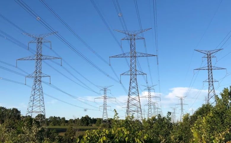 Electrical transmission lines set against a blue sky.