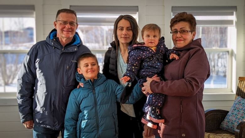 Grandparents, a daughter and two grandchildren in winter jackets 