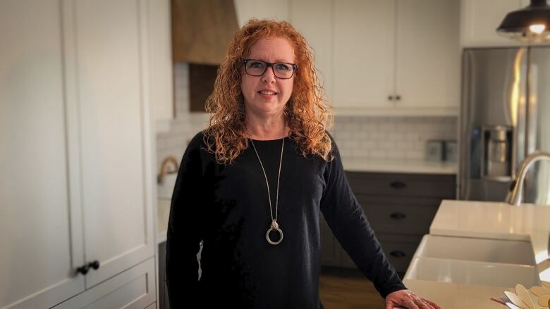 A woman stands in a modern kitchen 