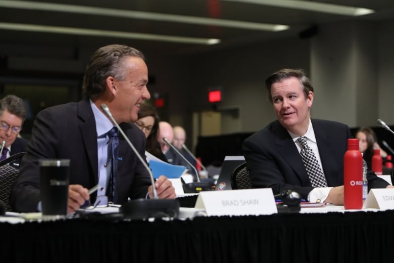 Edward Rogers and Brad Shaw share a smile at the CRTC hearing into approving the merger of their two companies.