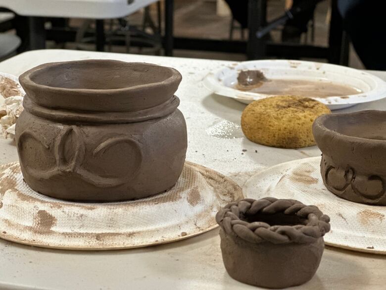 Three clay pots on a table.