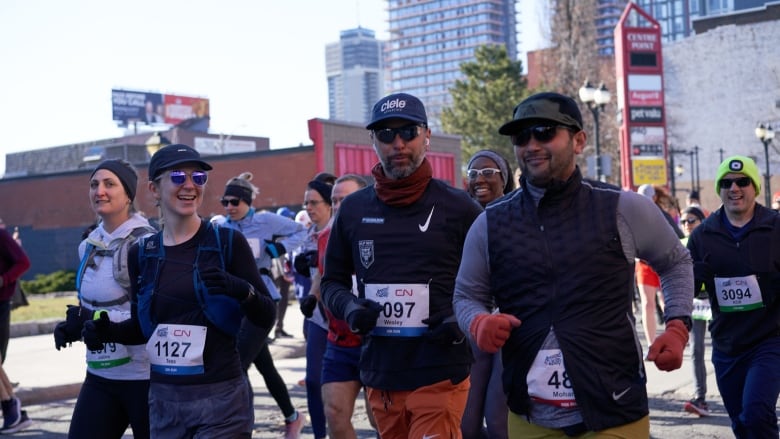 People run through downtown streets. 