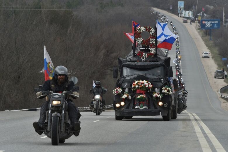 A motorcycle leads a convoy.