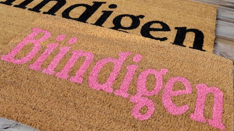 A doormat with the word 'biindigen' is painted on it.