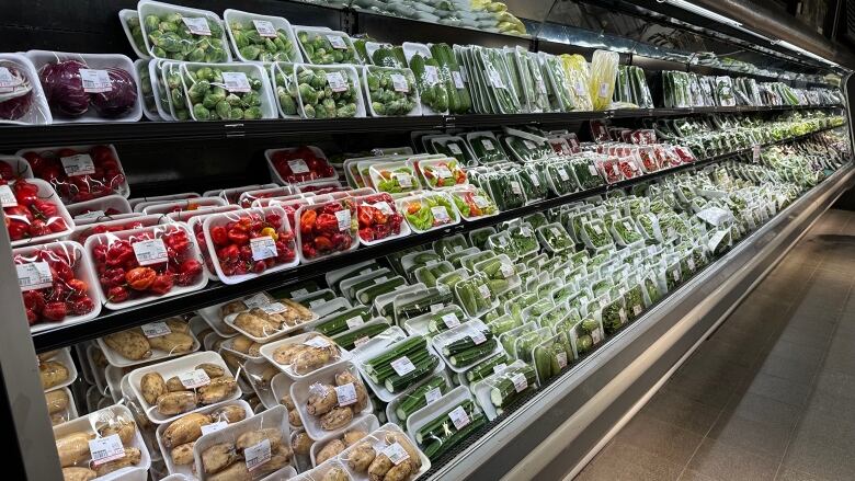 Grocery store produce aisle where all products are packaged with plastic and thermal labels. 